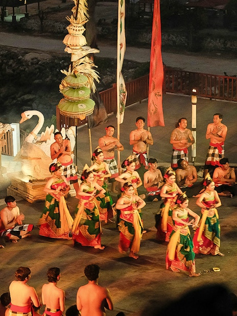 Kecak and Fire Dance performance by the beach in Bali, featuring traditional costumes and chanting circle.