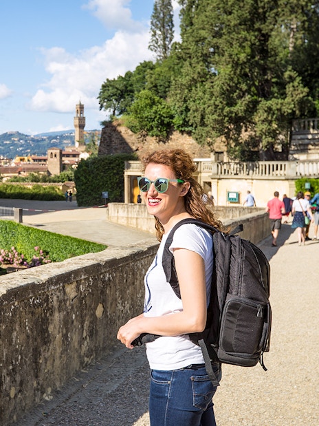Visitor enjoying a sunny day at Boboli Gardens, Florence, with the Duomo in the background.