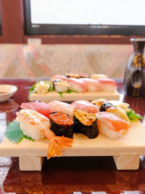 Sushi platter and sake bottles on Tokyo Day Tour: Sakura Cruise.