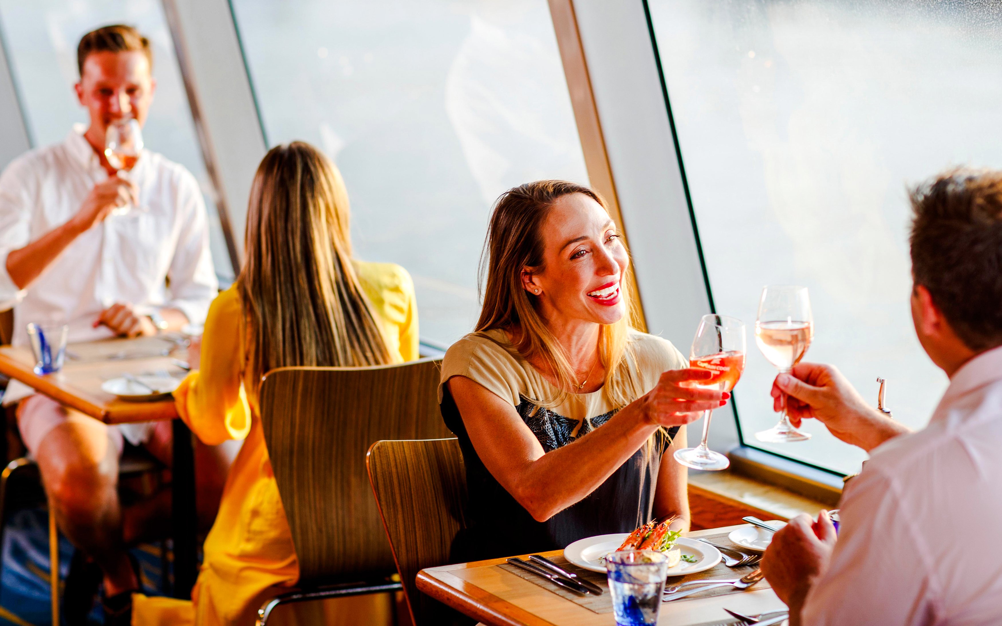 Guests toasting with wine on a Sydney sunset cruise dining experience.