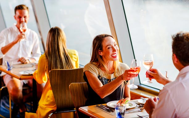 Guests toasting with wine on a Sydney sunset cruise dining experience.
