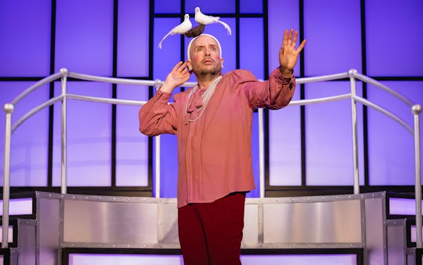 Performer on stage in Titaníque show with doves on headpiece.
