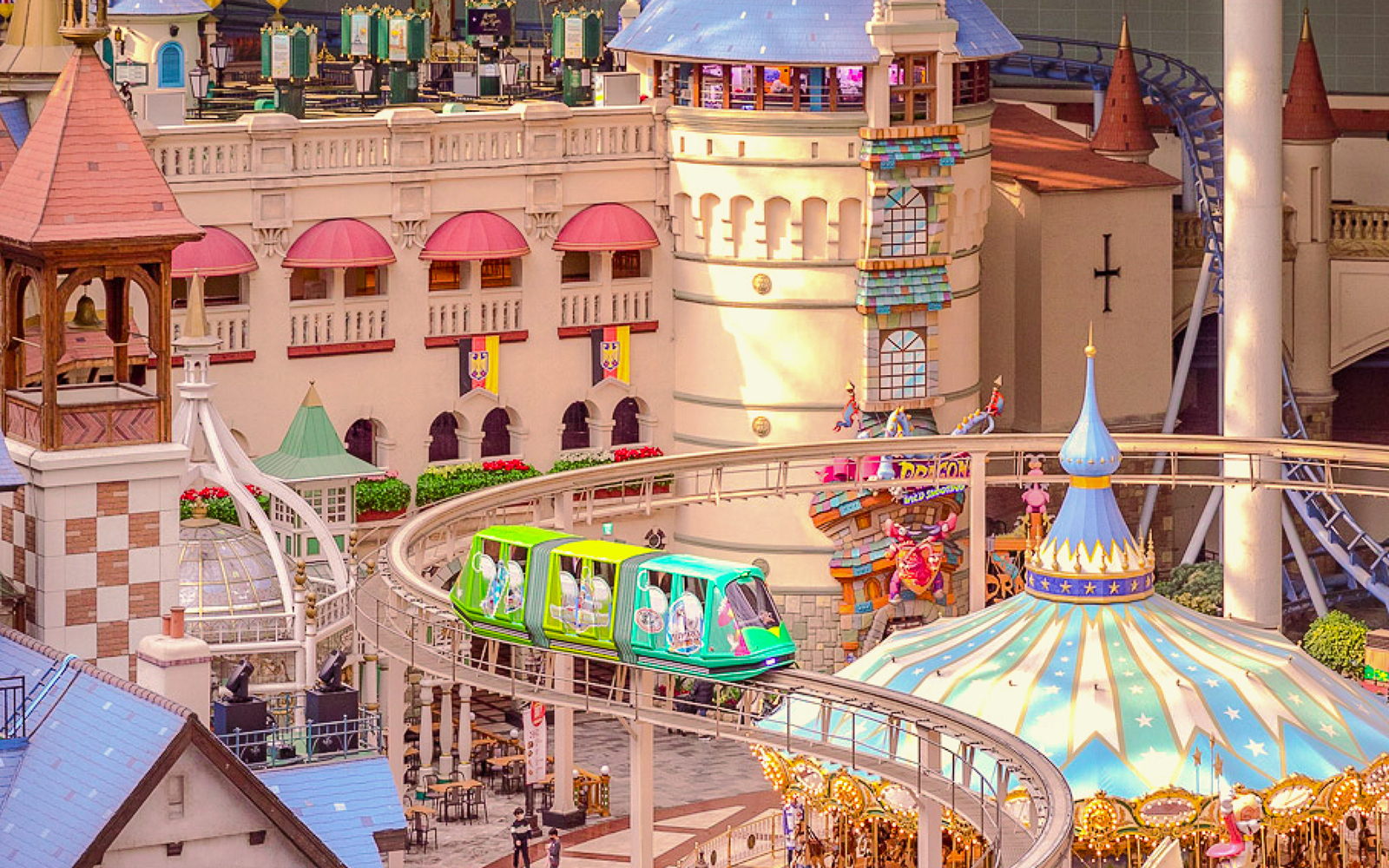 Lotte World indoor amusement park monorail passing colorful castle structures.