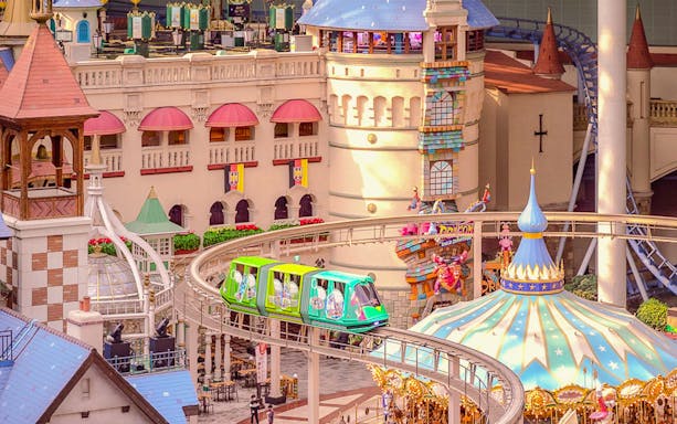 Lotte World indoor amusement park monorail passing colorful castle structures.