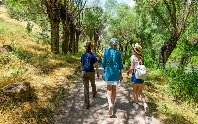 Guests walking through a tree-lined path in Gerome Valley, Cappadocia.