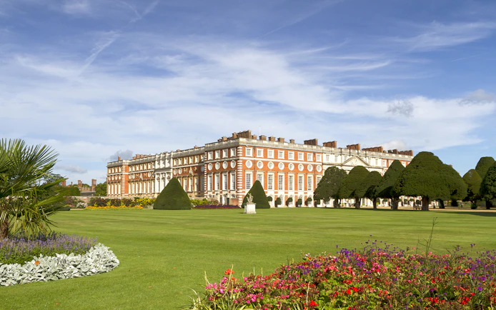 Hampton Court Palace with manicured gardens and colorful flowers, London.