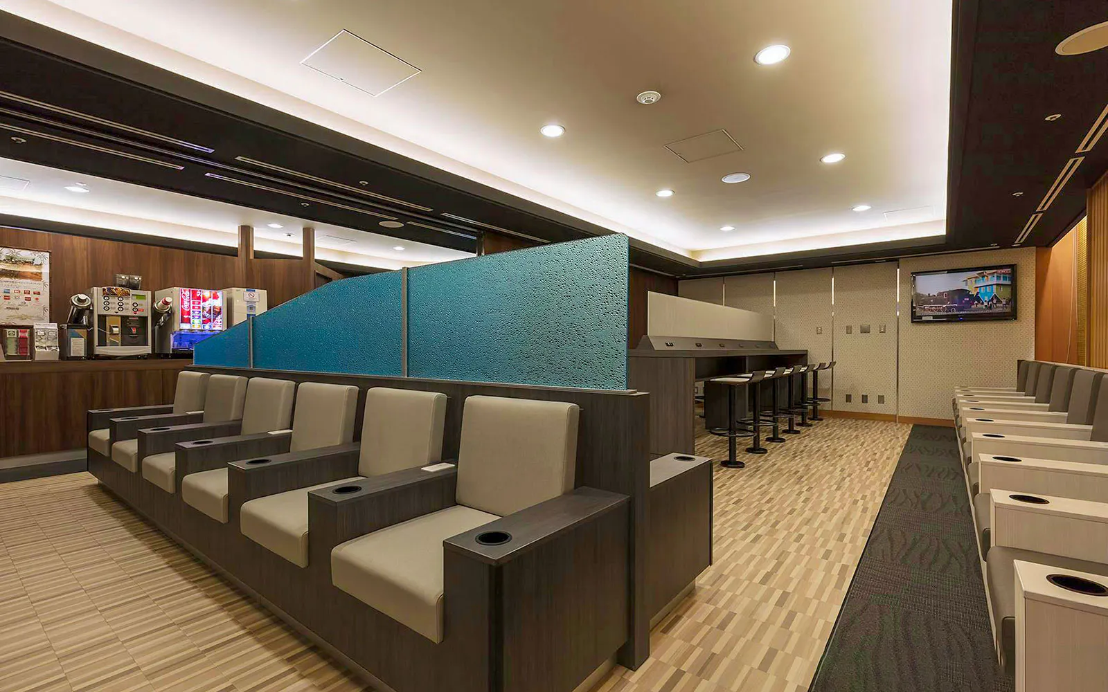 Waiting area seating at Narita International Airport Terminal 1 lounge with beverage station.