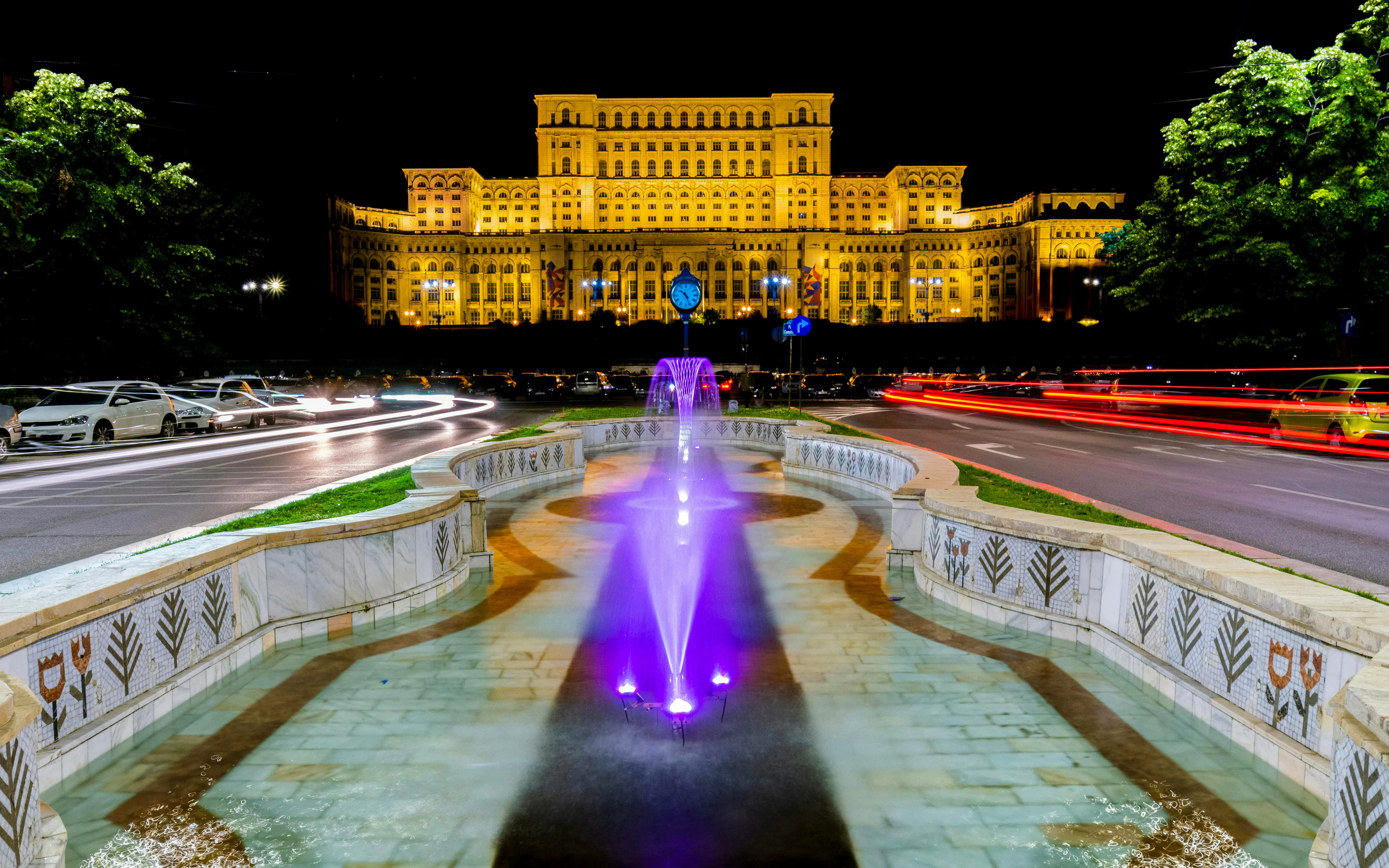 Palace of Parliament illuminated at night with fountain in foreground, Bucharest, Romania.