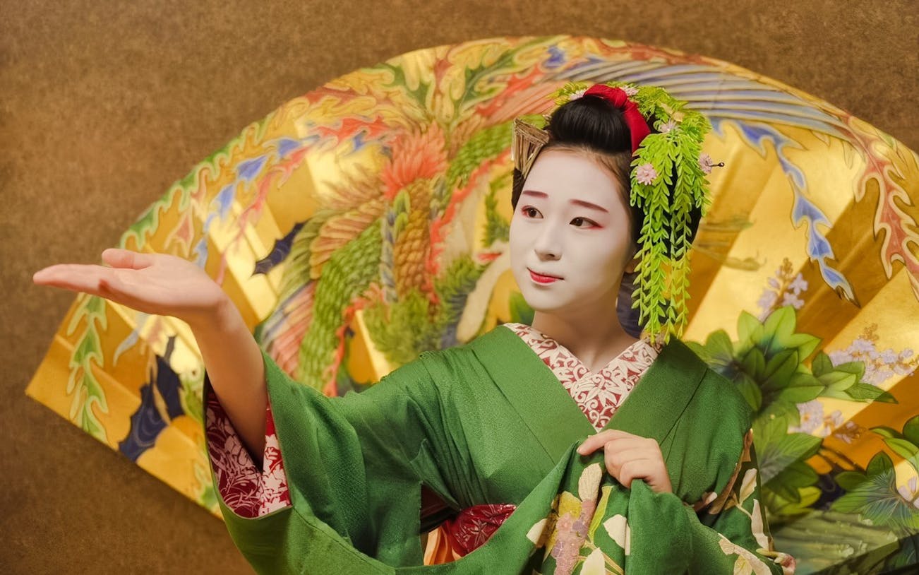 Geisha in traditional green kimono performing with ornate umbrella in Japan.
