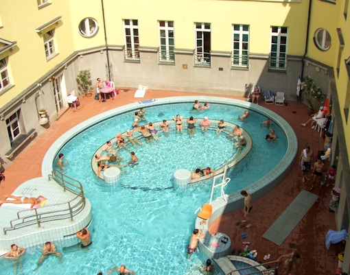 Lukacs Baths thermal pools in Budapest with people enjoying the warm waters.