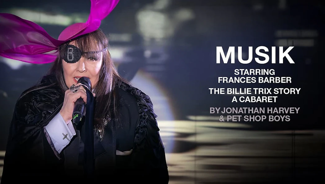 Performer with eyepatch and pink hat singing in "MUSIK" cabaret show.