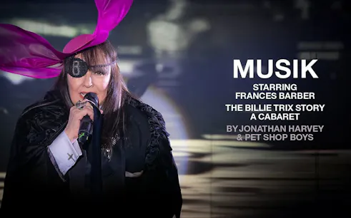 Performer with eyepatch and pink hat singing in "MUSIK" cabaret show.