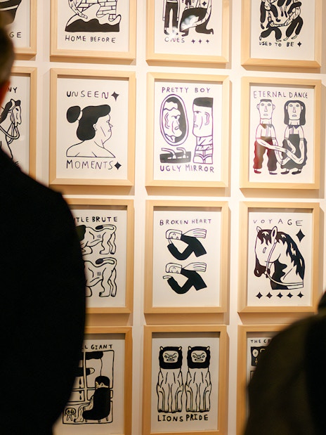 Visitors viewing framed artwork at Family & Legacy exhibition, Straat Museum.