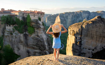 Guest overlooking Great Meteoron Monastery from a viewpoint in Meteora, Greece.