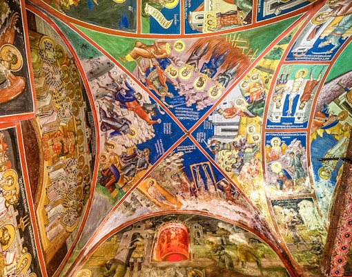 Interior view of Monastery of Varlaam with ornate frescoes and religious artifacts, Meteora, Greece.