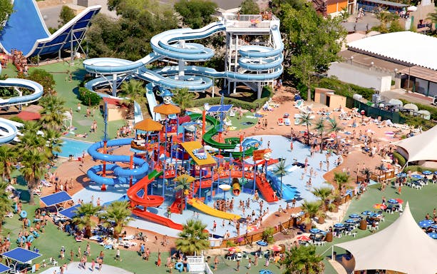 Aquasplash Antibes water park with colorful slides and pools, crowded with visitors enjoying the attractions.