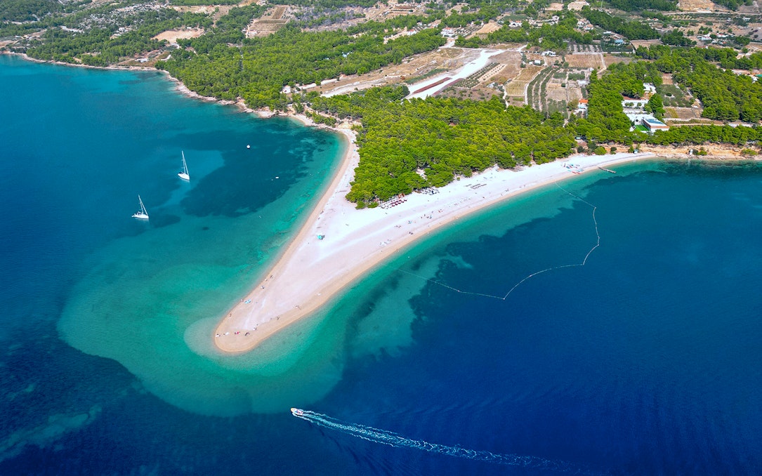 Golden Horn beach extending into the sea with boats near Bol Town, Brac Island.