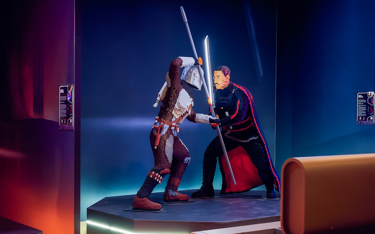 Mandalorian and Moff Gideon LEGO figures in battle at Star Wars exhibition.