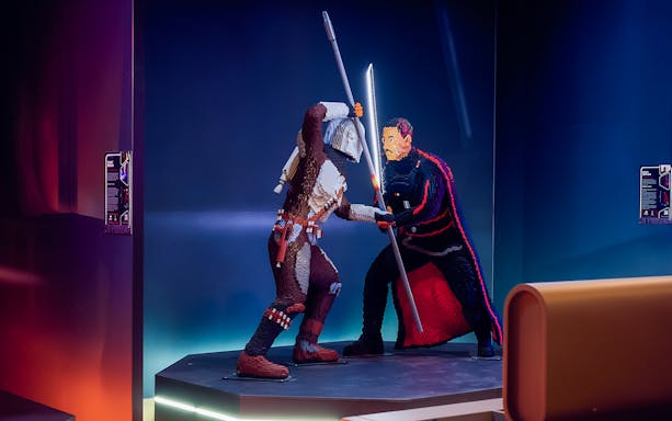 Mandalorian and Moff Gideon LEGO figures in battle at Star Wars exhibition.