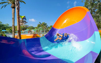 Water slide at Aquatica Orlando with people riding in a tube.