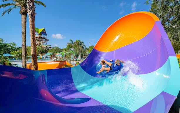 Water slide at Aquatica Orlando with people riding in a tube.