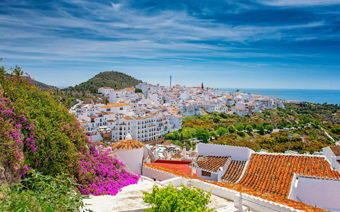 Whitewashed village of Frigiliana with sea and hills in the background.