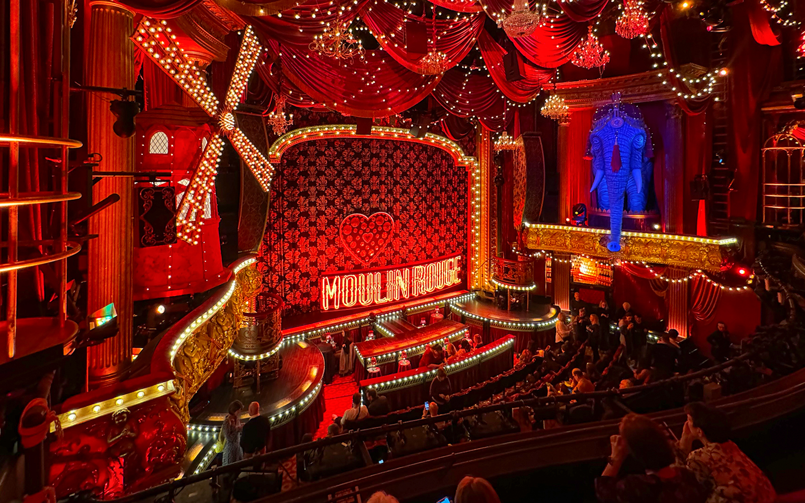 Moulin Rouge cabaret performance with dinner in Paris, featuring vibrant costumes and dancers.