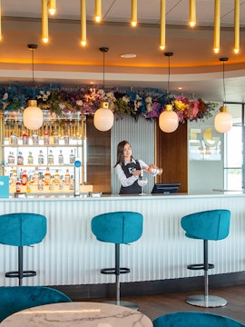 Bartender preparing a drink at Plaza Premium Lounge bar in Edinburgh.