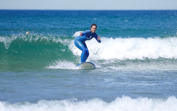 Surfer riding a wave during a lesson in Costa da Caparica.