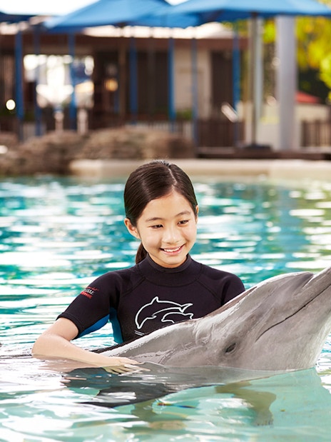 Girl interacting with dolphin at Dolphin Island, Resorts World Sentosa.