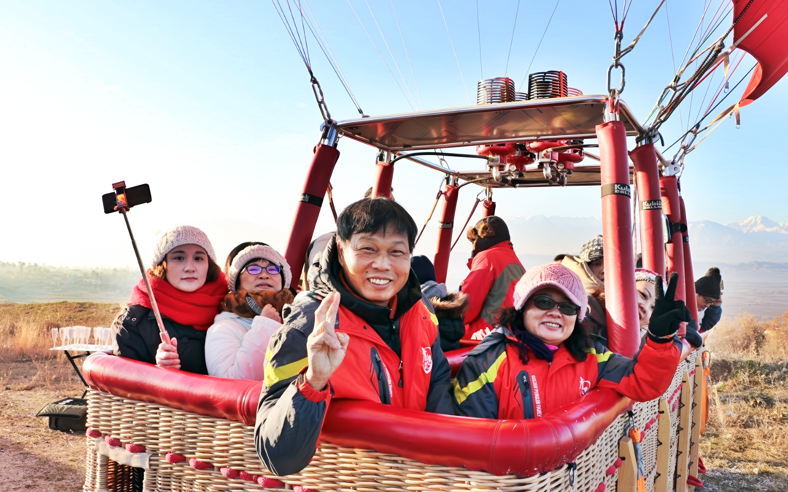 Hot air balloon passengers in Pamukkale preparing for flight with scenic landscape in background.