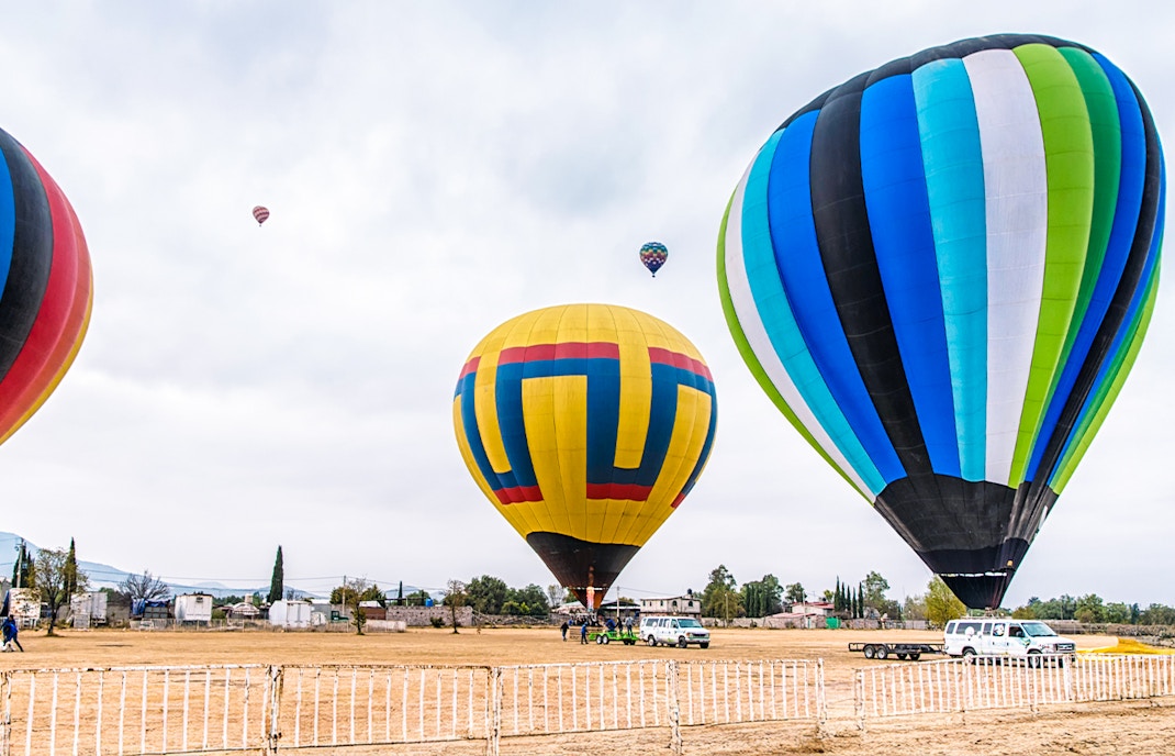 Teotihuacan hot air balloon preparation with colorful balloons on the ground, Mexico.