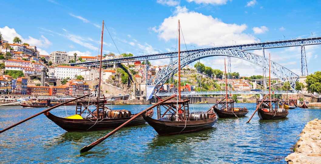 Douro River cruise boat with Porto cityscape in the background.