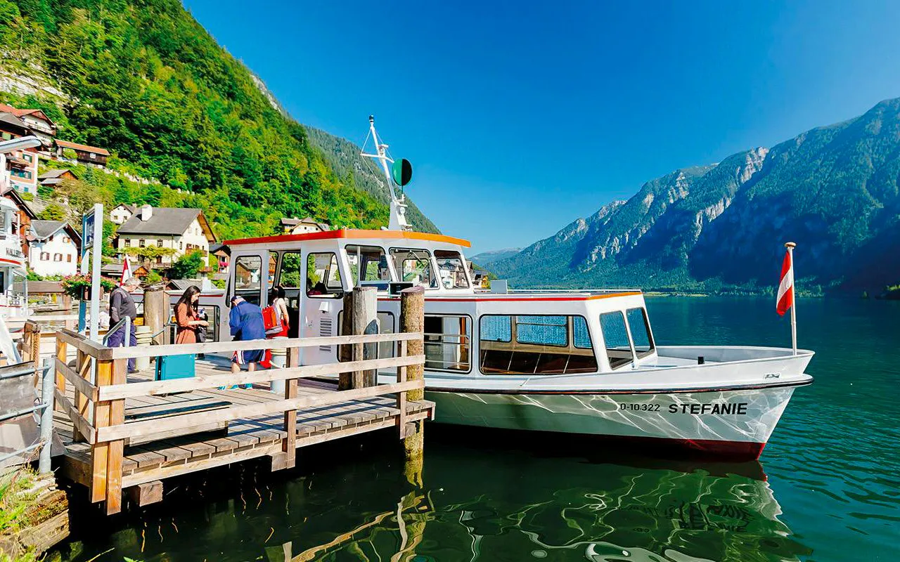 Boat docked at Hallstatt lake with mountains in the background, part of Vienna day trip.