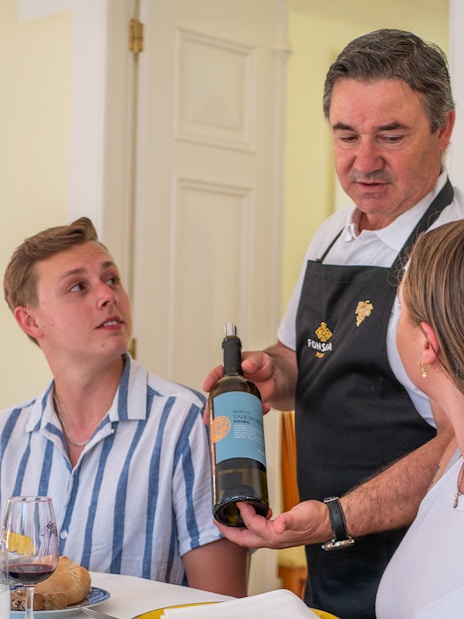 Tourists being served wine during lunch on Douro Valley Full-Day Tour.