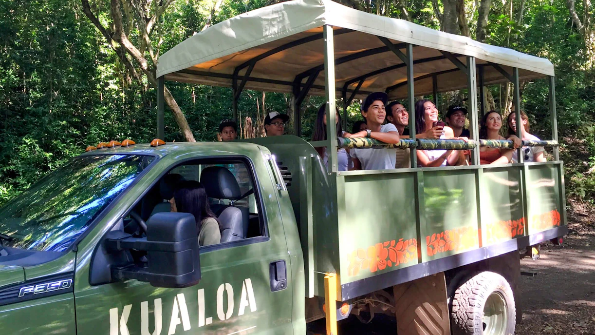 UTV tour group exploring Kualoa Ranch, Hawaii in an open-air vehicle.