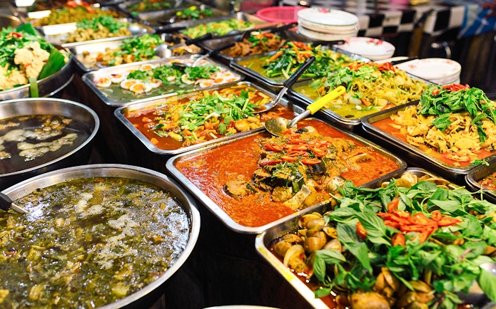 Street food dishes at a local market in Phuket, Thailand.