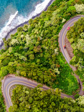 Winding coastal road through lush greenery on the Road to Hana, Maui, Hawaii.