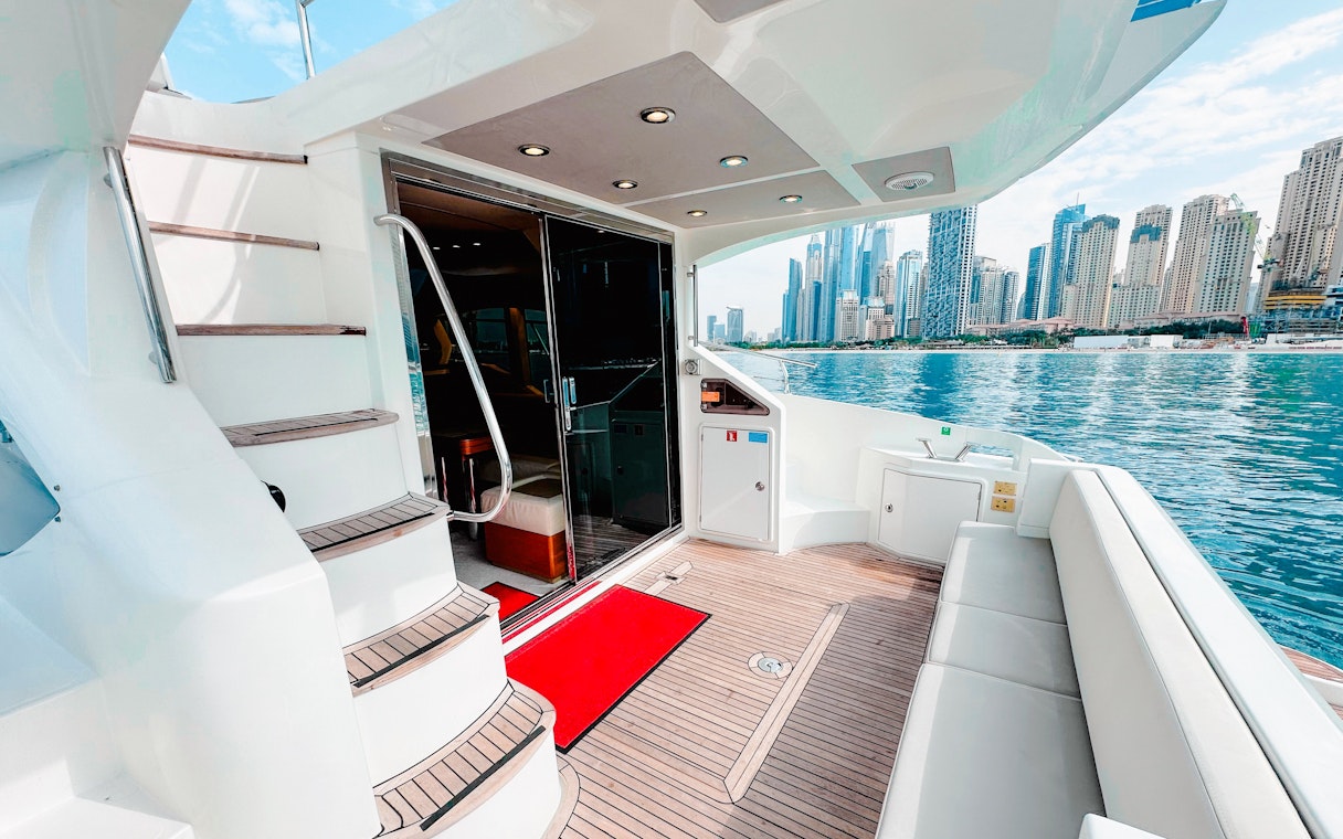 Inside view of a luxury yacht with Dubai skyline in the background.