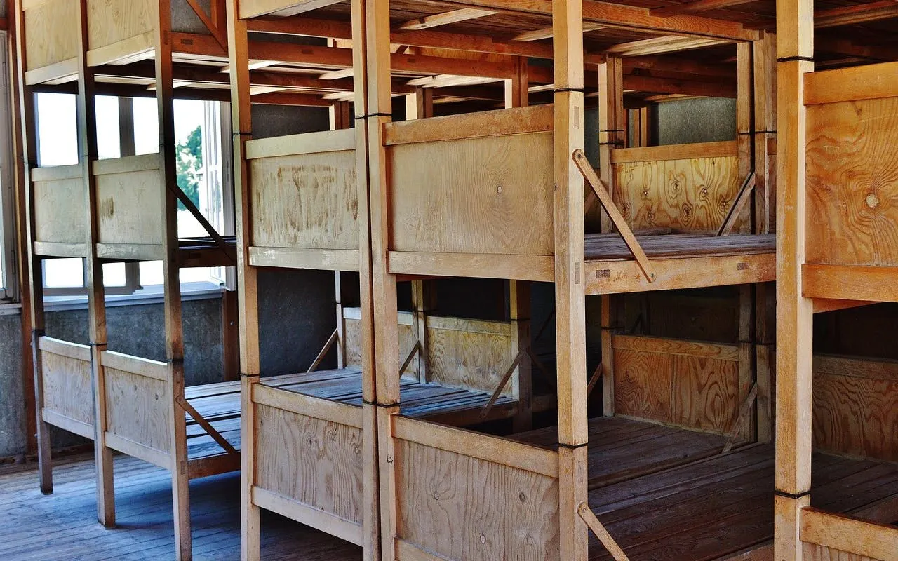 Wooden bunk beds at Dachau Memorial Site, part of a guided day trip from Munich.