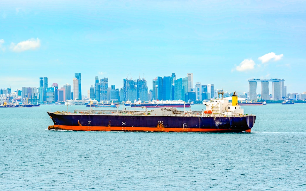 LPG tanker sailing through Singapore Strait with city skyline in background.