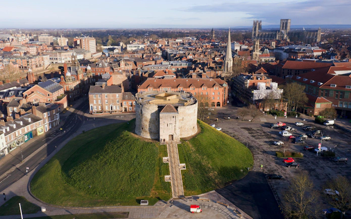 Clifford's Tower in York, England, surrounded by historic cityscape.