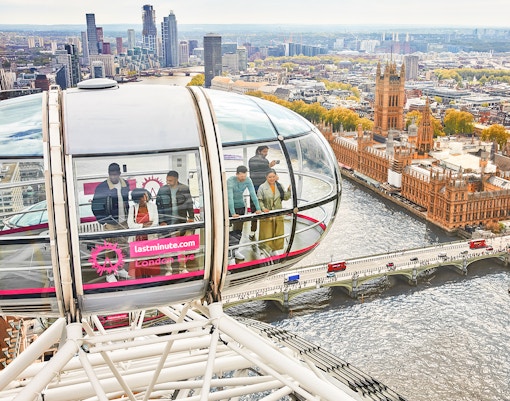 Visitors inside a London Eye capsule overlooking the River Thames and Big Ben.