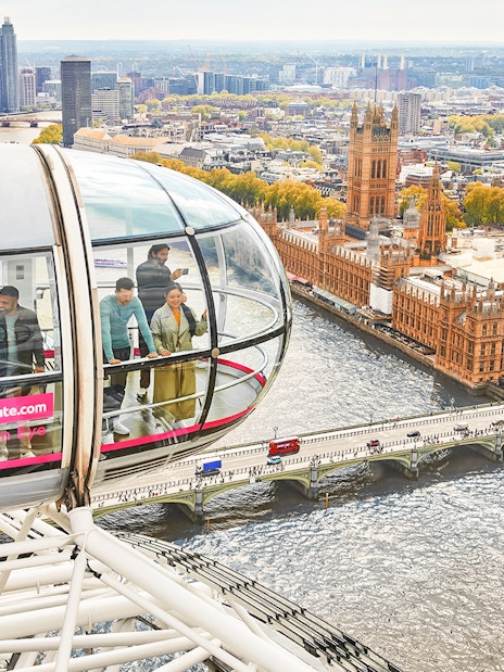Visitors inside a London Eye capsule overlooking the River Thames and Big Ben.