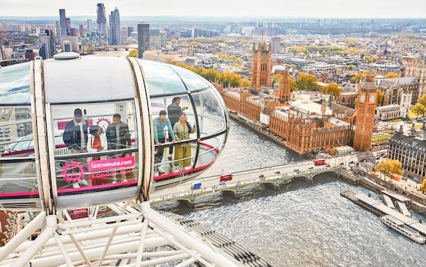 Visitors inside a London Eye capsule overlooking the River Thames and Big Ben.