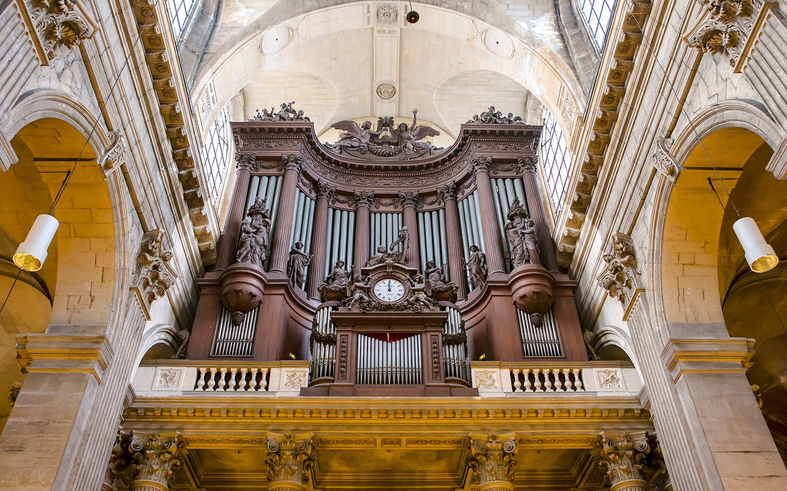St Sulpice Church interior with ornate pipe organ and detailed sculptures.
