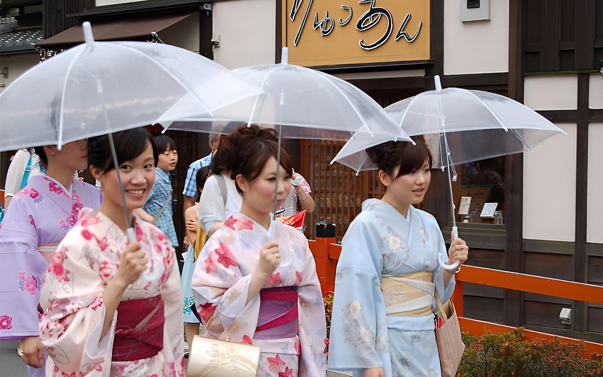 Women in kimonos with umbrellas walking in Asakusa, Tokyo.