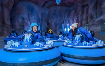 Visitors enjoying bumper cars at Snow Abu Dhabi indoor snow park.