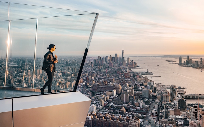 Person standing on New York's Edge Observation Deck with city skyline and Hudson River view.