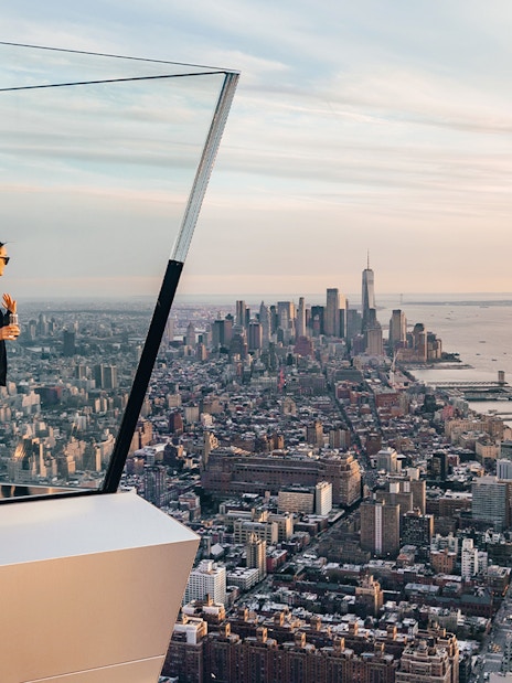 Person standing on New York's Edge Observation Deck with city skyline and Hudson River view.
